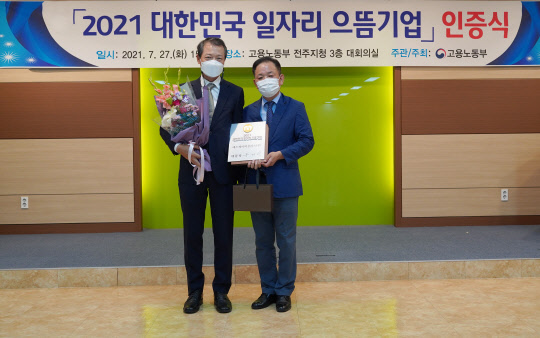 이재홍(왼쪽) SK넥실리스 경영지원총괄과 전현철 고용노동부 전주지청장이 27일 고용노동부 전주지청에서 열린 '2021 대한민국일자리 으뜸기업 인증식'에서 대통령 인증패를 받았다. <SK넥실리스 제공>